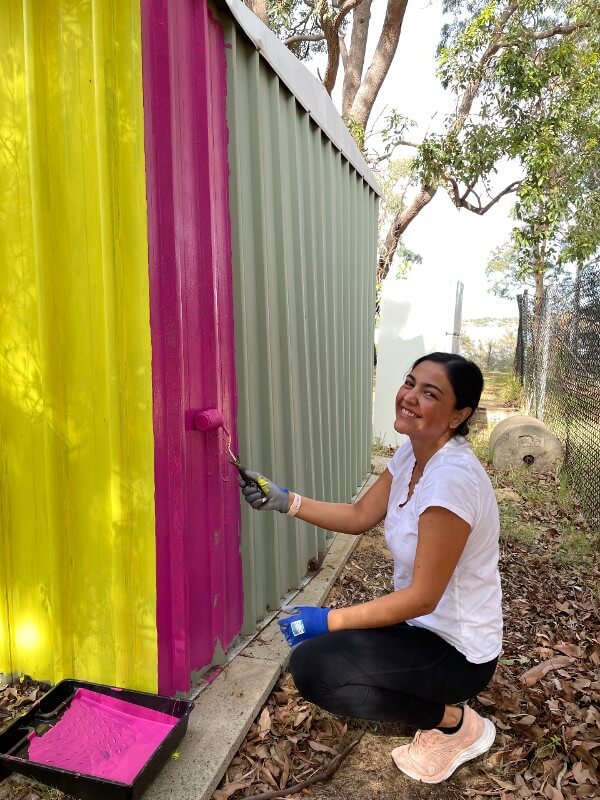 Volunteer painting a fence